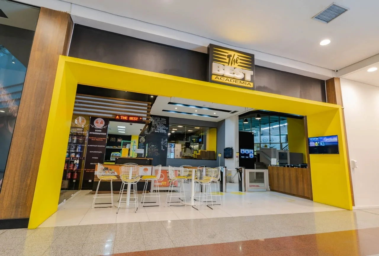 Entrada da The Best no Shopping Mueller, com portal amarelo e logo