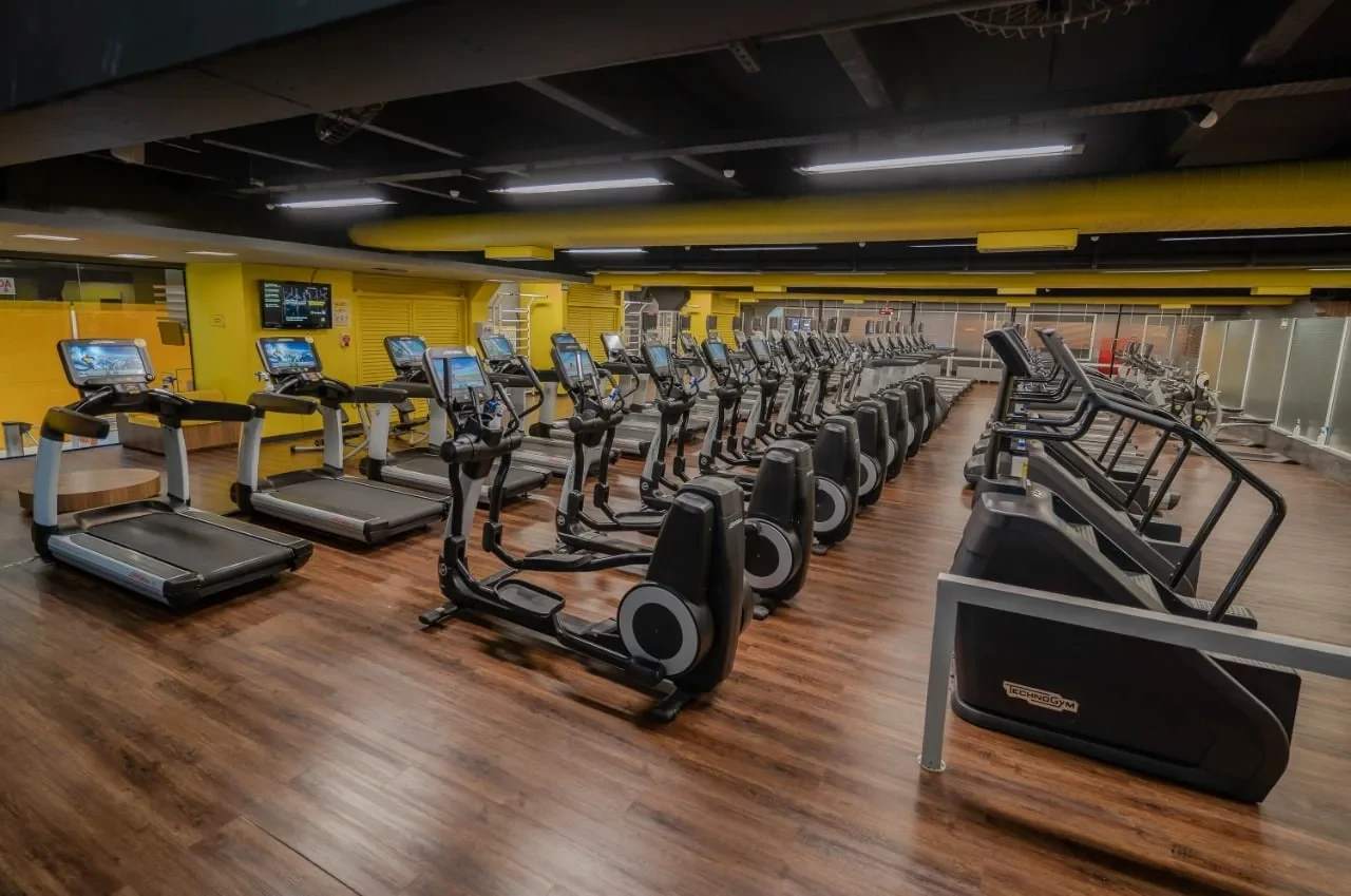 Área ampla de cardio da The Best, com esteiras, elípticos e escadas